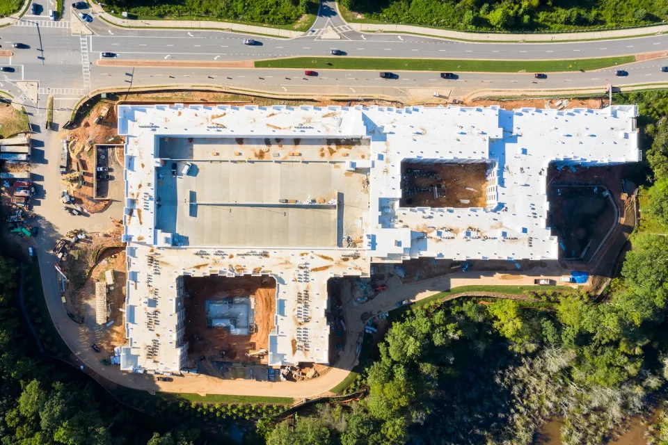 Bird's eye view of large apartment complex under construction next to four-lane road near Atlanta, Georgia.